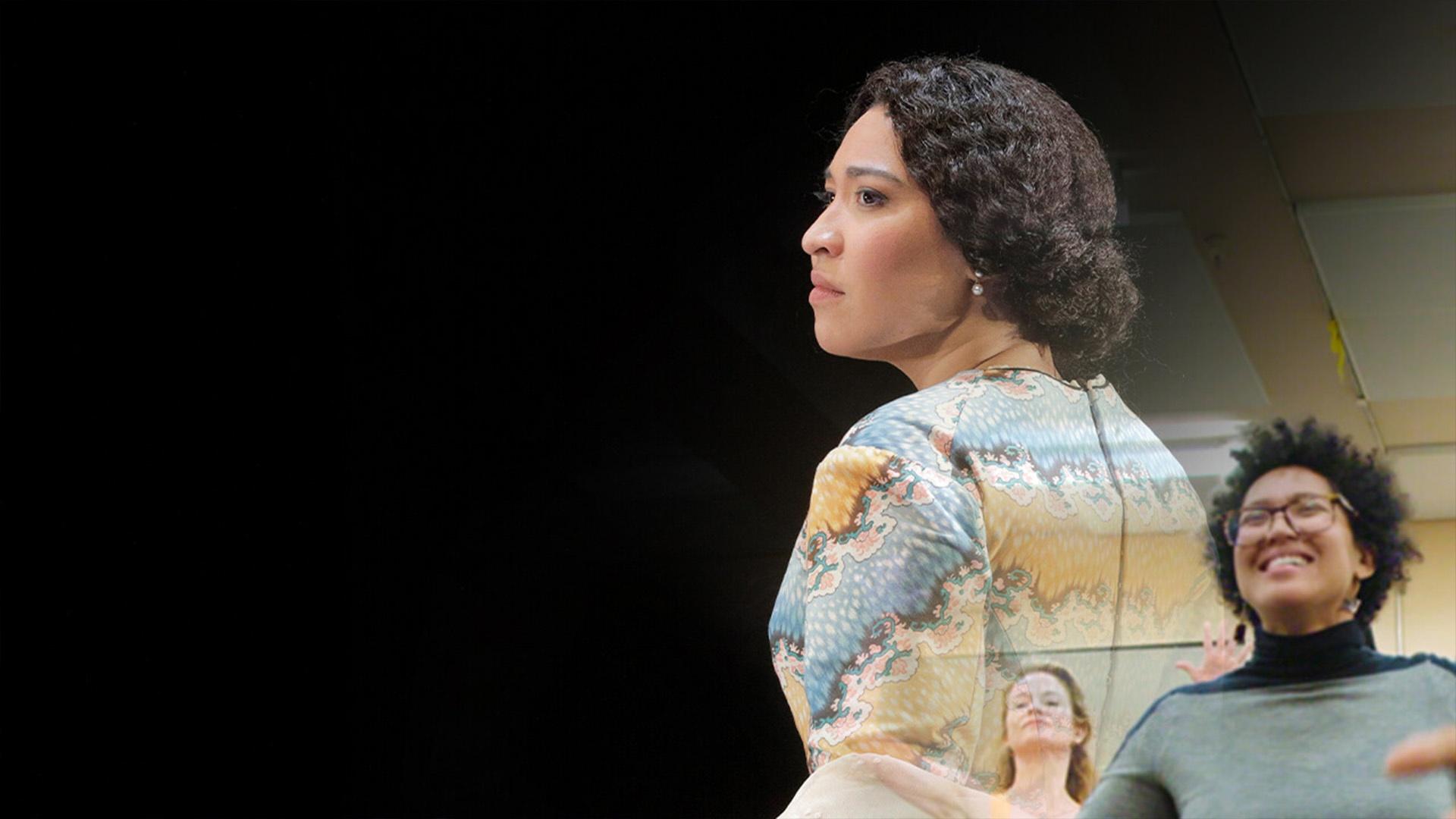 A montage of two Black woman - one, wearing a blue sweater rehearsing for the play. The other wearing a blue, yellow and white print dress.