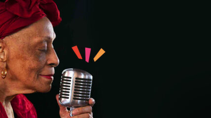 Music legend Omara Portuondo singing into a mic