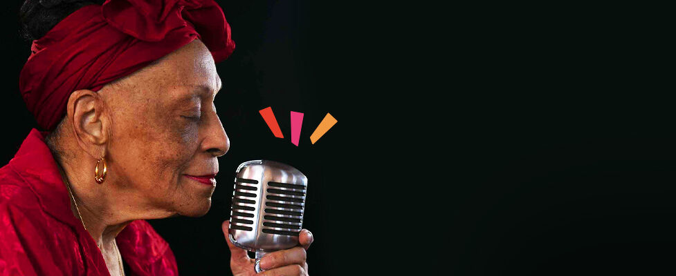 Music legend Omara Portuondo singing into a mic