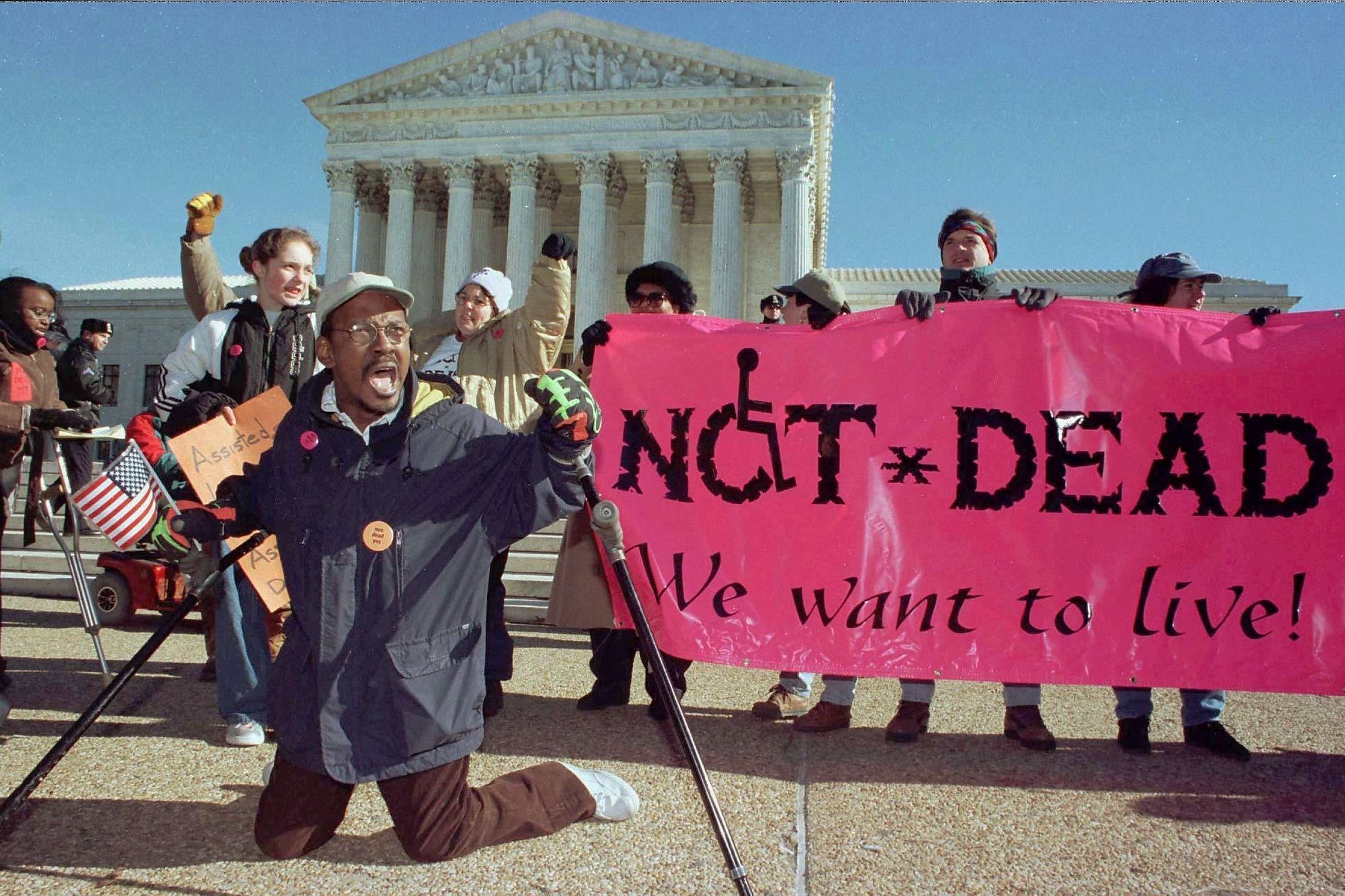 A group of people in front of the Washington DC holding a sign that reads "Not Dead Yet!"