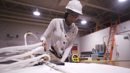 Journey to Jobs photo of worker in a hard hat looking at plans