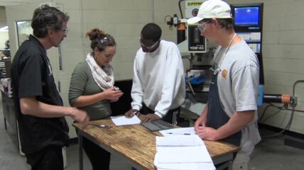 Group gathered around a work table.