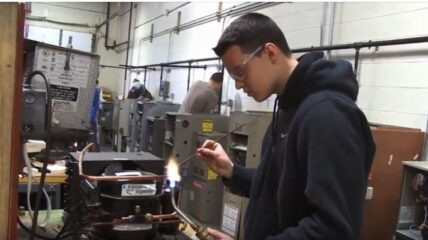 Student wearing safety glasses at a workbench