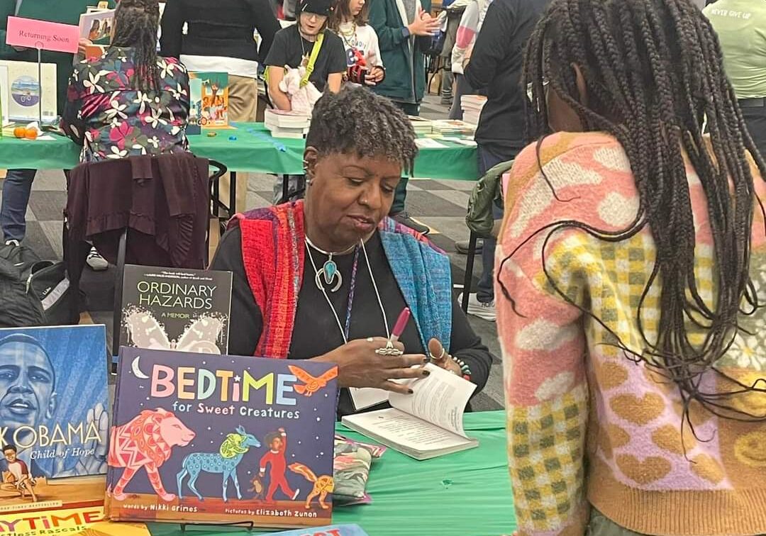 Children's author signing a book for a fan