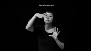 An Asian woman signing in ASL against a dark background. Above her are the words: Into disconnect.