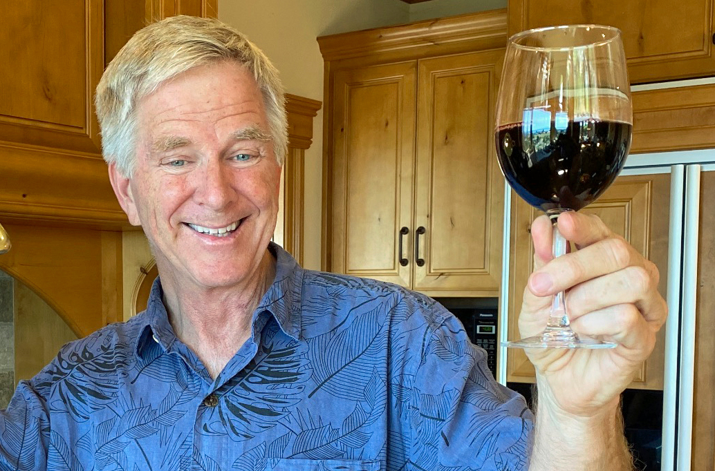 Rick Steves holding up a glass of red wine.