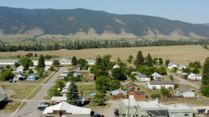 A overhead view of a neighborhood with a mountain range behind it.