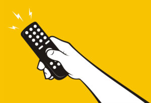 Hand holding operating a remote control for TV or stereo