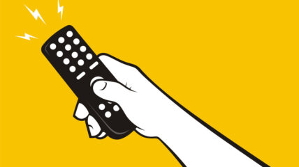 Hand holding operating a remote control for TV or stereo