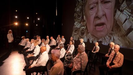 Seniors from the Young@Heart choral group on a stage seated waiting to perform