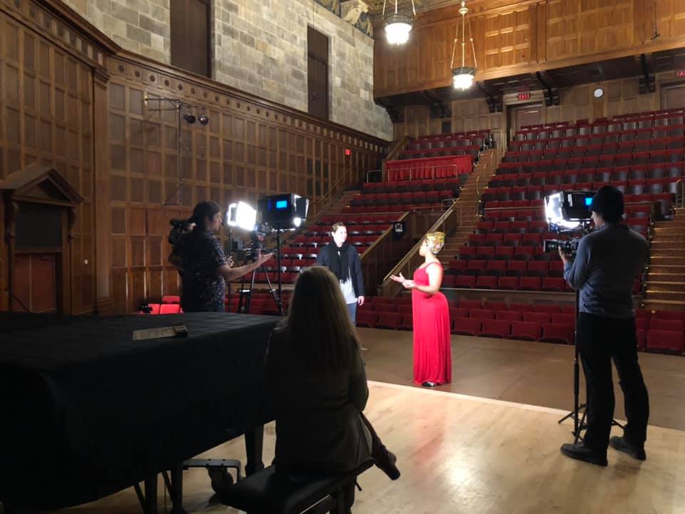 Black female dancer on stage and a camera crew in the background