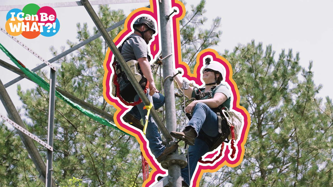 Two technicians climbing a tower wearing helmets and safety equipment