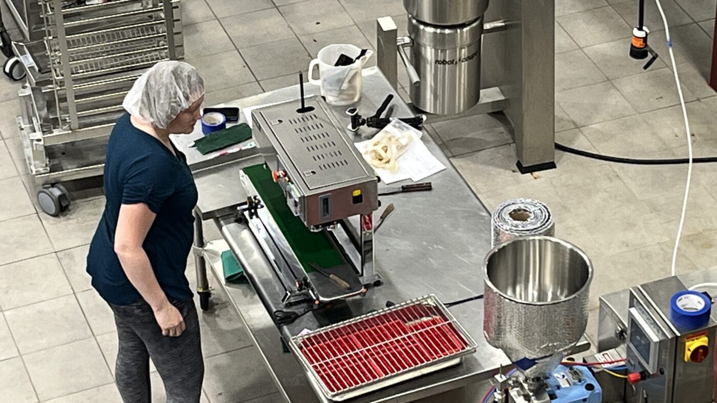 Woman with hairnet working at station in a food plant