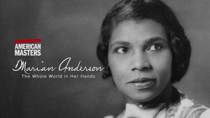 A Black woman with short Black hair and a light colored blouse stares off the side.