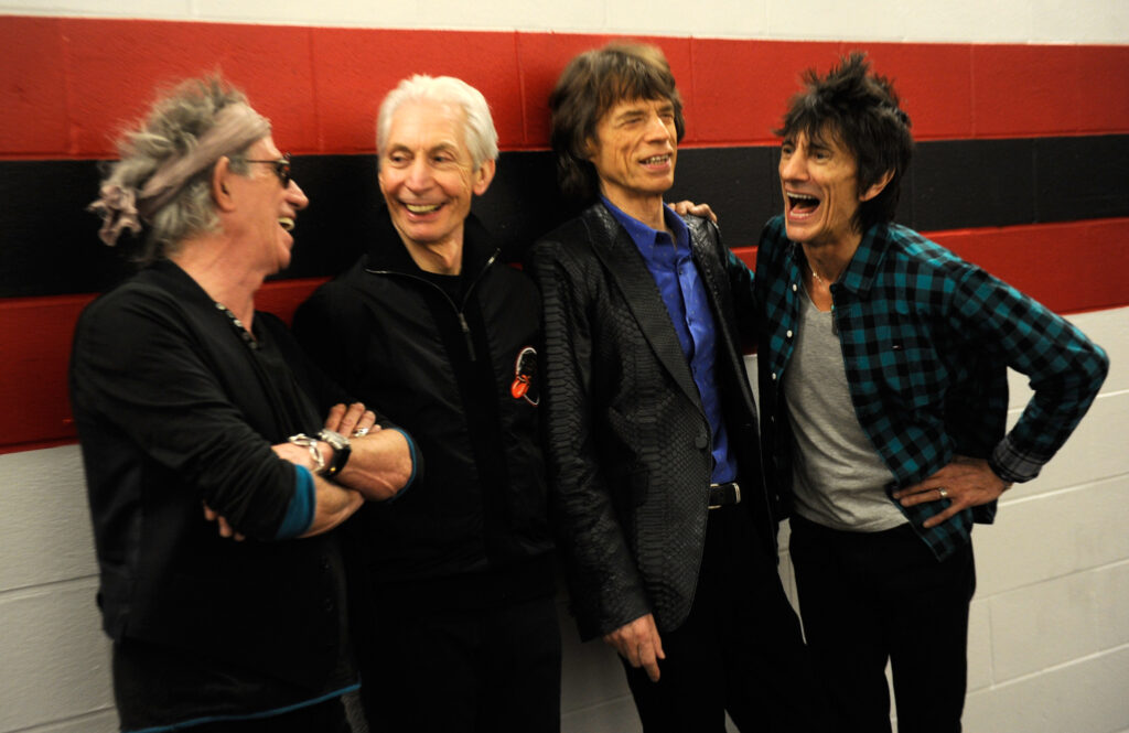 A photo of the band members of The Rolling Stones. Four white males standing together in a row.