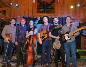 folk band with guitars shown. There are 6 members they are all white.