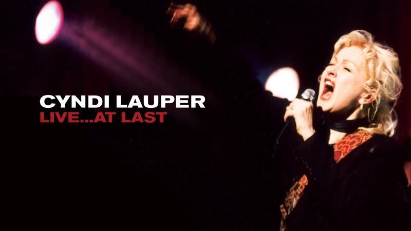 cyndi Lauper shown singing into a microphone