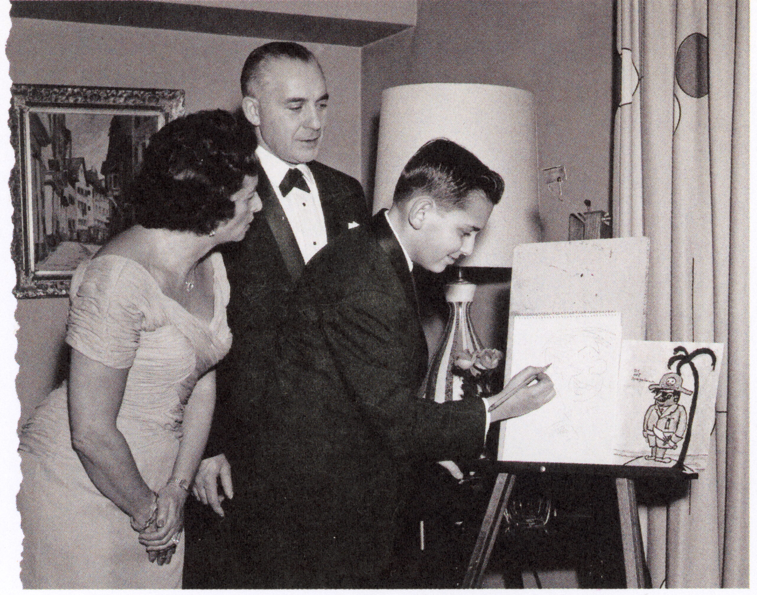 A young Art Spiegelman signing one of his illustrations with his parents watching him