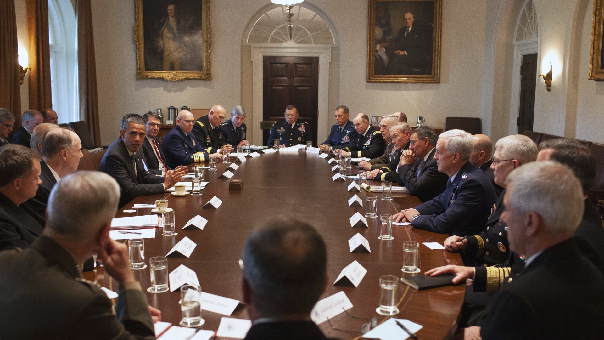 Barack Obama sitting at a table with a bunch of Generals