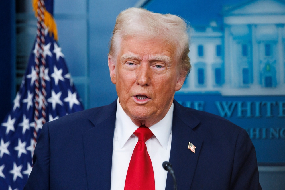 President Donald Trump in front of a flag behind a podium