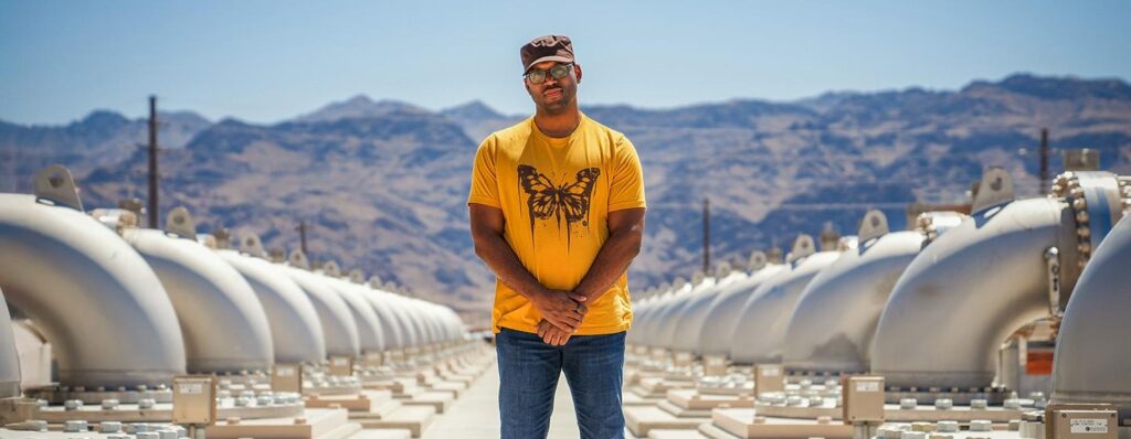 A Black man standing in front of a vast water facility.