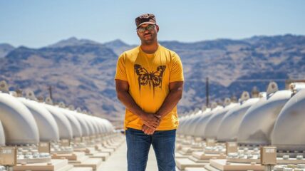 A Black man standing in front of a vast water facility.