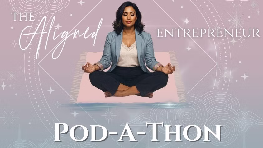 A Black woman wearing a light blue blazer, white shit, and navy pants sits with her legs crossed with hands resting onher knees.