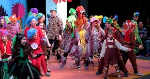 A group of kids on stage acting out a play.