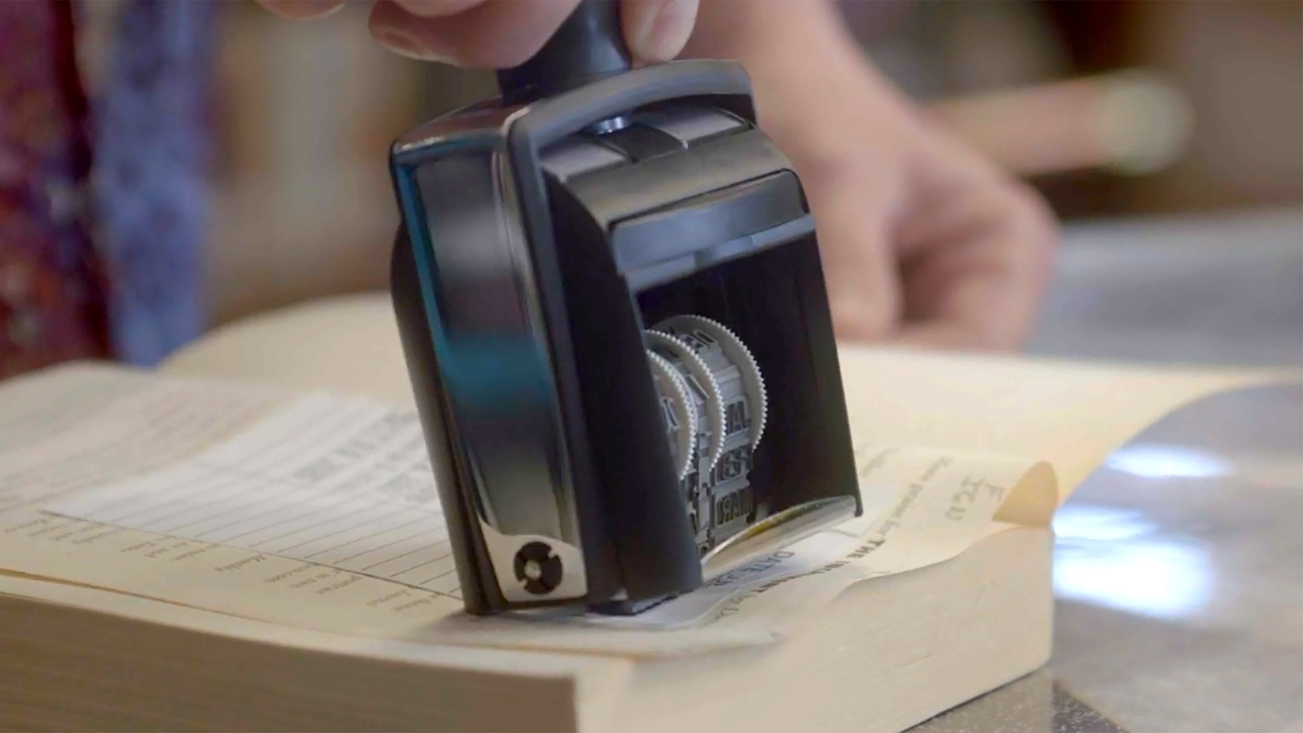 A book opens and being stamped with a date.