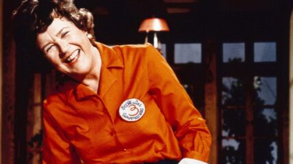 Julia Childs wearing a red blouse laughing