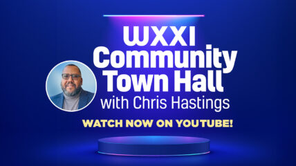 WXXI President Chris Hastings wearing a gray shirt and blue blazer with copy in white text on a blue background that reads: WXXI COMMUNITY TOWN HALL with Chris Hastings WATCH NOW