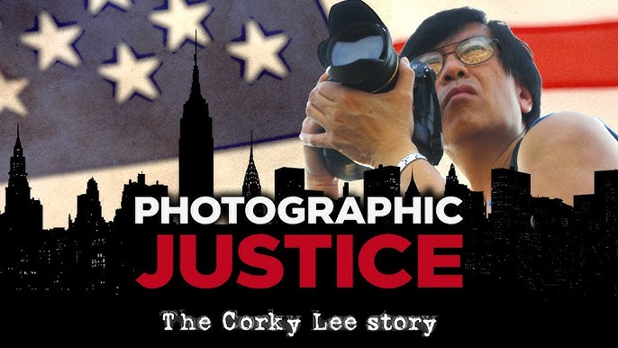 Corky Lee in a black ank and wearing black rimmed glasses holds a camera. Behind him is the American flag and in front of him is the silhouette of a city. Words over the city read Photographic Justice The Corky Lee Story