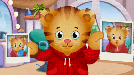 Daniel Tiger holding two photographs