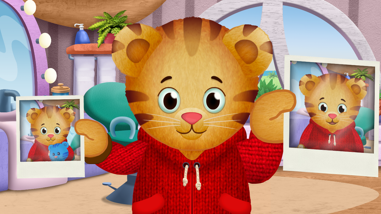 Daniel Tiger holding two photographs